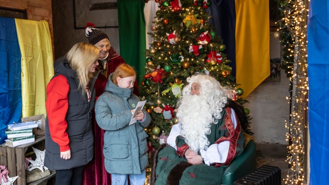 A mother and daughter meet Father Christmas and Mrs Claus in the Reverse Grotto at Chirk Castle, Wrexham.